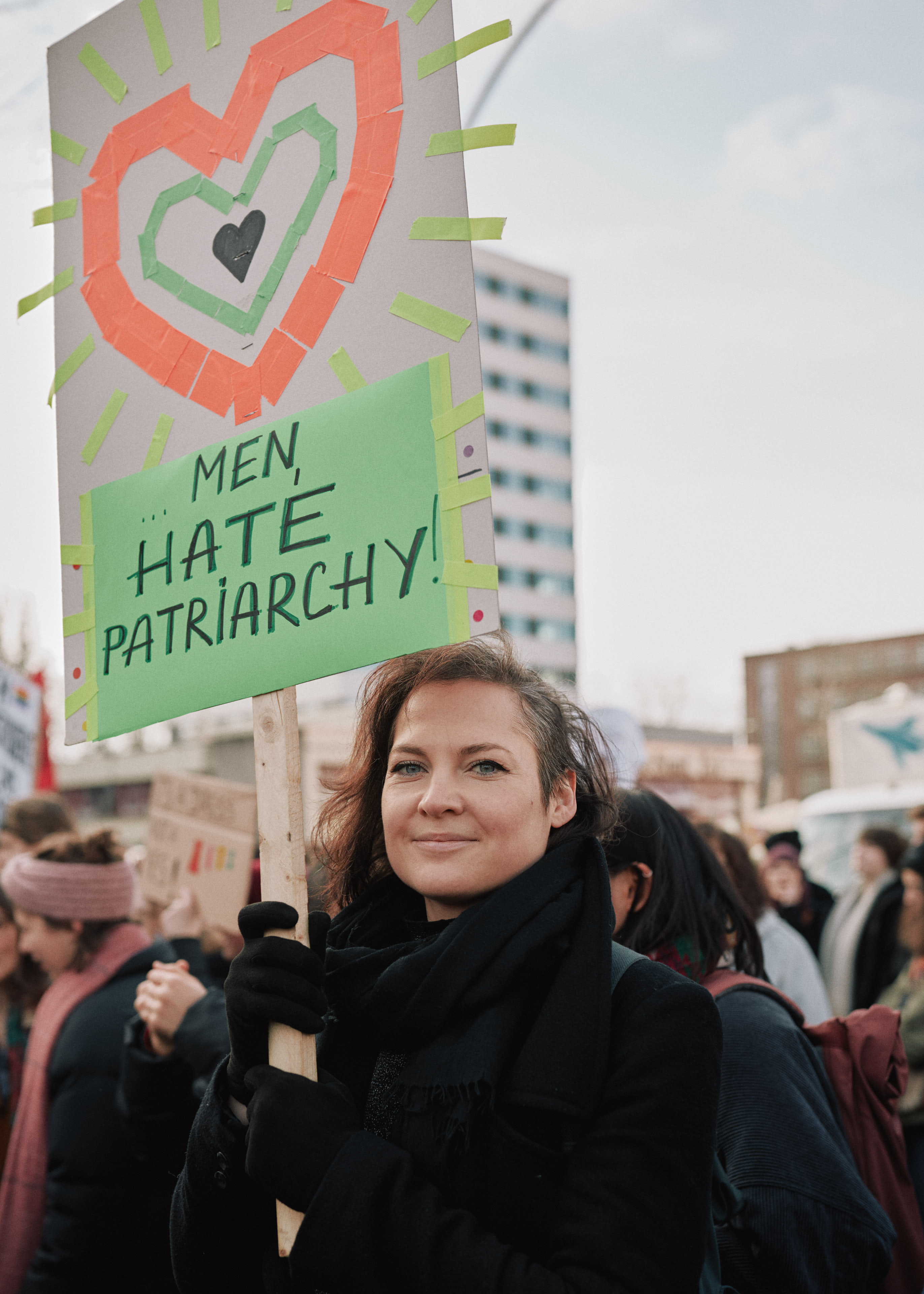 Alina holds a sign "Men hate patriarchy"